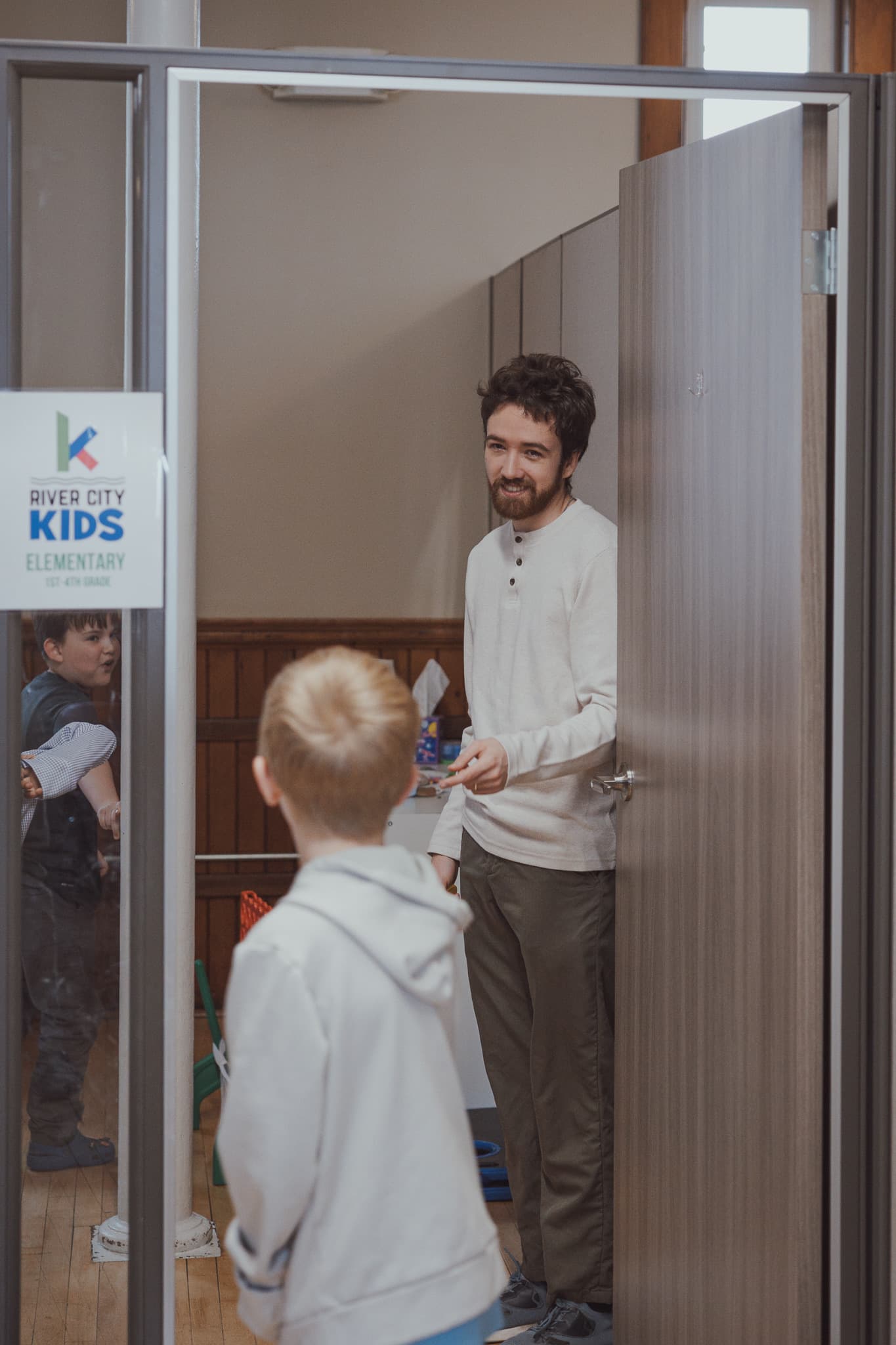 A River City Kids volunteer welcoming children into the classroom